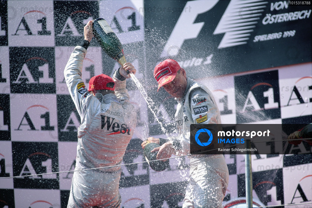 Mika Hakkinen, 1st position, and David Coulthard, 2nd position, celebrate on the podium. Mika Hakkinen, 1st position, and David Coulthard, 2nd position, celebrate on the podium.